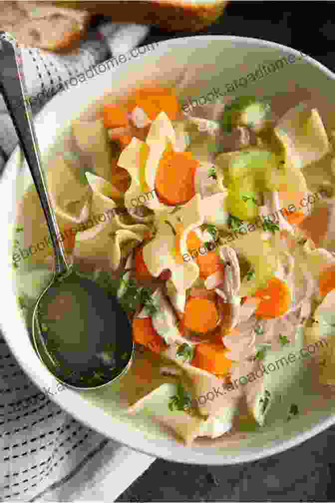 A Steaming Bowl Of Golden Chicken Noodle Soup, Garnished With Fresh Parsley And A Sprinkle Of Black Pepper Learn The Art Of Cooking Soup: 80 Cozy Recipes For Creative Plant Based Soups And Stews To Share